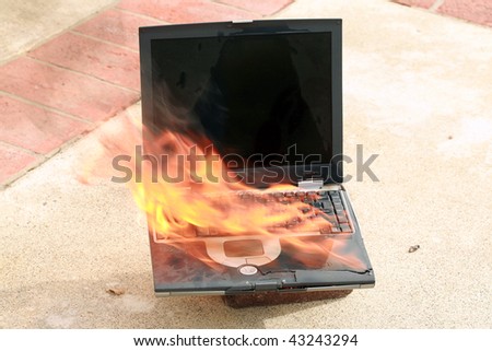laptop computer on fire, represents computer damage, loss of data, emergency and more