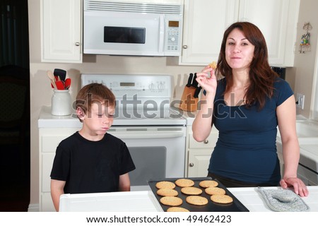 a mother and son enjoy hot fresh baked cookies after school in the kitchen