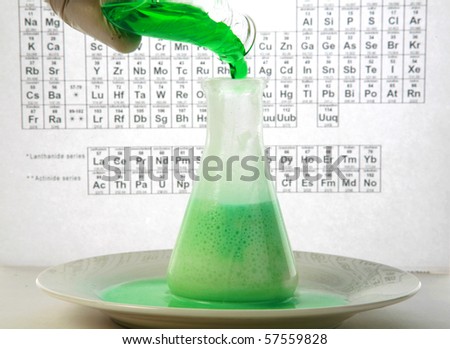 a chemist or research scientist adds chemicals to a erlenmeyer flask with a pipette for a violent chemical reaction