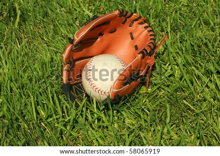 baseball glove and base ball lay in a grass field