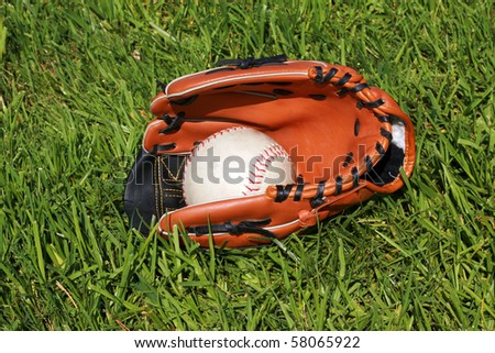 baseball glove and base ball lay in a grass field