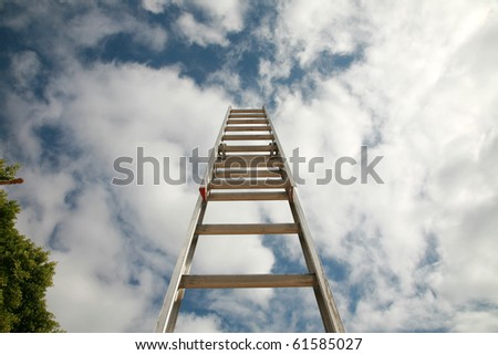 ladder to success, extention ladder extened into the blue sky with great white fluffy clouds. representing success in business, reaching for the stars or clouds, ladder of success, corporate ladder