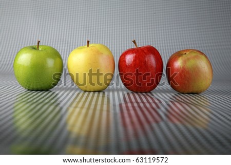 four diffrent fresh picked apples of red green and gold on a black and white background