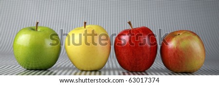 fresh picked green. yellow, red, and red-gold apples on a black and white background