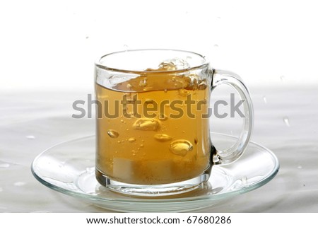 hot tea splashes as a lemon slice or sugar cube is dropped into it making a mess and splashing all over