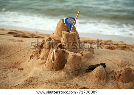 the remains of a childs sand castle on the beach of maui right before the tide washes it away