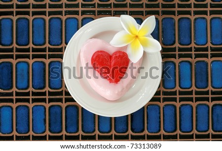 Valentine\'s day theme - Cake with a beautiful plumeria flower on a blue tile background