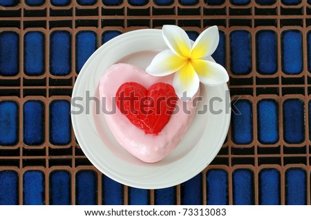 Valentine\'s day theme - Cake with a beautiful plumeria flower on a blue tile background