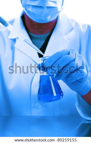 a medical research scientist or chemist works in a laboratory. light in a blue light. blue being a popular color for health, science, calm, relaxation, and just generally a great cool color
