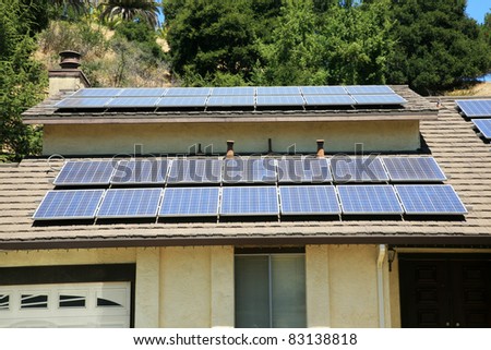 alternative energy photovoltaic solar panels on the roof of a home. collecting energy from the sun and helping save the earth from global warming and reducing their electric bills at the same time