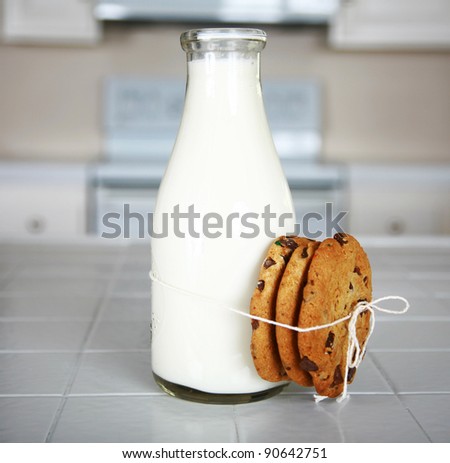 Cookies and Milk with an antique glass milk bottle on a kitchen counter for a after school snack of 