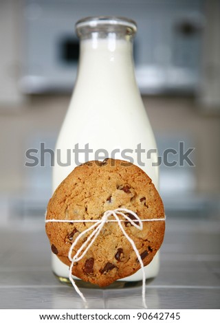 Cookies and Milk with an antique glass milk bottle on a kitchen counter for a after school snack of \