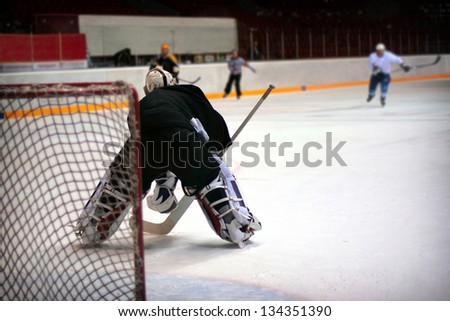 Hockey goalie in generic black equipment protects gate
