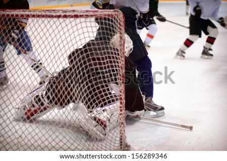 Hockey goalie in generic black equipment protects gate