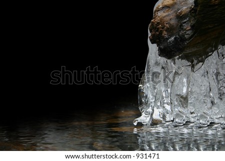 A semi-frozen river with icicles.  Left 2/3 black for add space or wallpaper for icons in PC.