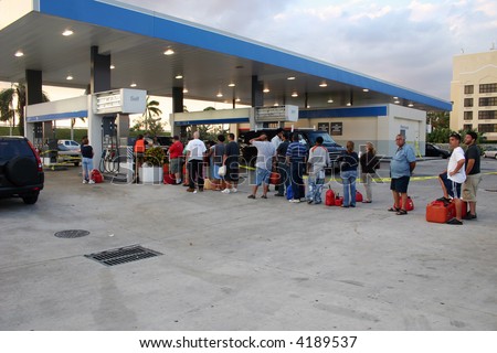 People with empty containers waiting in line to buy gasoline. [NAME BRANDS REMOVED]