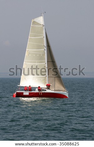 The command of seamen prepares for start of a regatta on a red yacht with gold sails