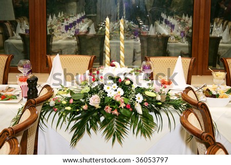  The served celebratory wedding table decorated with flowers and candles