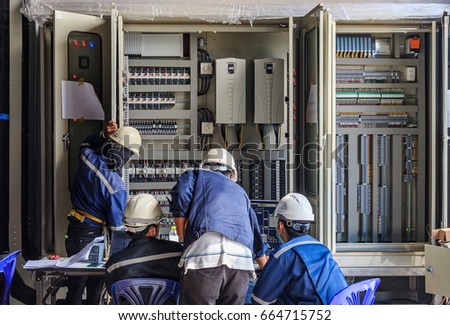 Engineer working on checking and maintenance equipment at wiring on PLC cabinet, Engineer checking status step up transformer