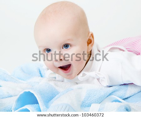happy baby girl crying on a blue towel