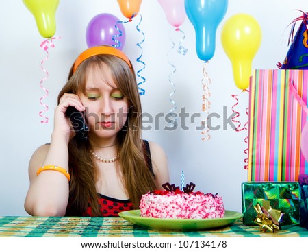 Sad birthday. Young sad girl talking on the phone
