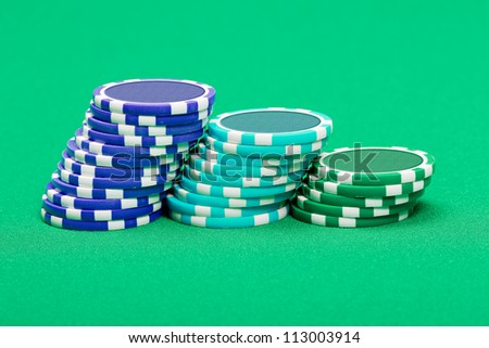 pile of playing chips on the green table