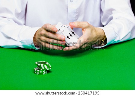 Card player shuffles the cards. green table