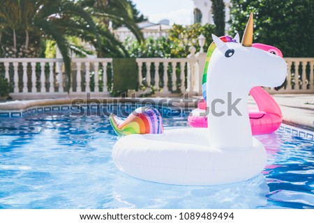 Inflatable colorful white unicorn at the swimming pool. Fun time in the Summer at swimming pool. concept