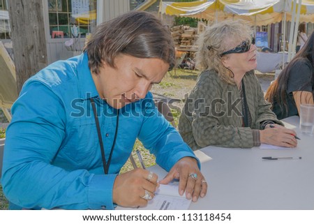 EDEN MILLS, ON - SEPTEMBER 16:  Prize winning Canadian writers Waubgeshig Rice and Eva Stachniak sign their books at the annual Writers Festival in Eden Mills, Ontario on September 16, 2012.