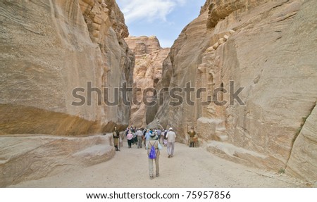 Tourists hike the ancient chasm leading to spectacular Petra,Jordan