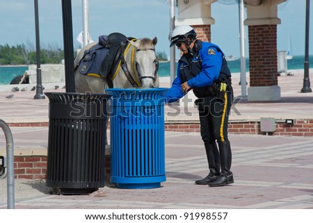 KEY WEST, FLORIDA - DEC 1: Policeman cares for his horse in Key West on December 1, 2011. Key West\'s Police Department is a full-service agency servicing over 25,000 residents and 6 square miles.