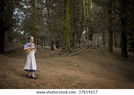 young girl expresing wonder dressed as Alice in Wonderland in a forest