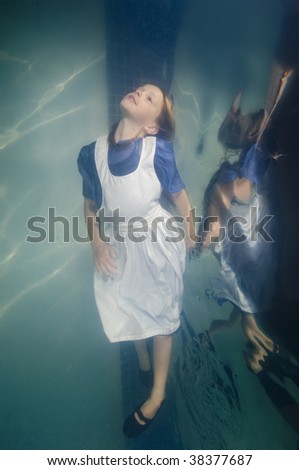 young girl swimming underwater in a dress