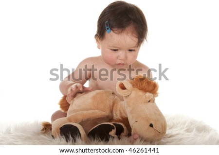 baby playing with stuffed horse toy animal