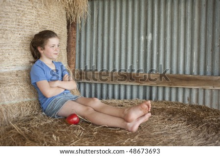 little girl (7 years old) sitting on bales of hay and relaxing in Canterbury barn  MR