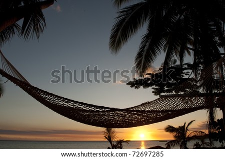hammock on beach at sunset in Fiji Islands