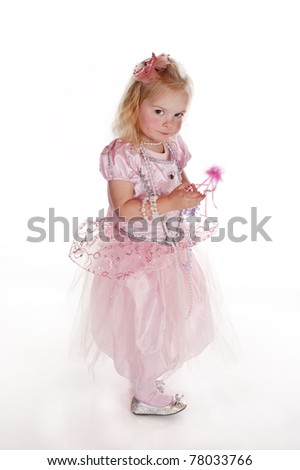little girl in pink fairy dress with mischievous expression against white background