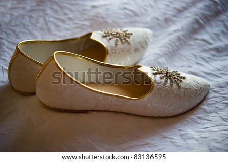 stock photo Image of men's Indian wedding shoes on a bed