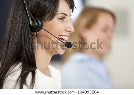 Two colleagues working in a busy call centre office.