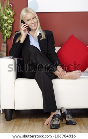 Young woman sitting on a sofa chatting on the phone
