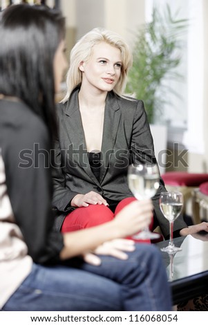 female friends enjoying a drink together at a wine bar.