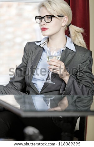 Attractive business woman in a wine bar waiting for a client or meeting.