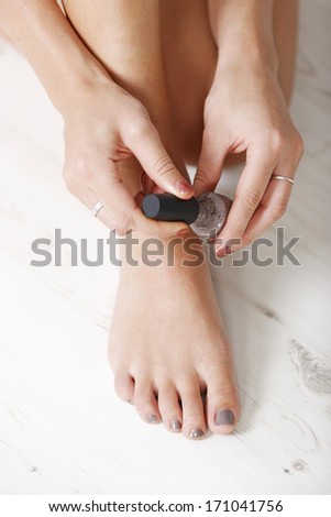 Woman applying nail varnish