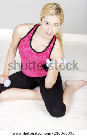 Young woman weight training with dumb bells