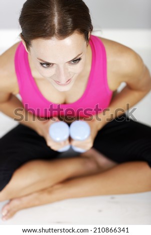 Young woman weight training with dumb bells