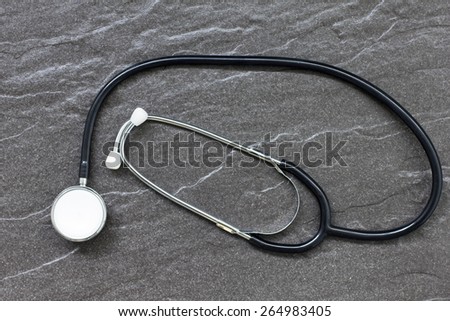 Still life of doctors medical stethoscope on a stone surface