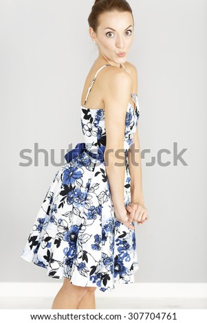 Beautiful young woman in a flowing blue summer dress having fun
