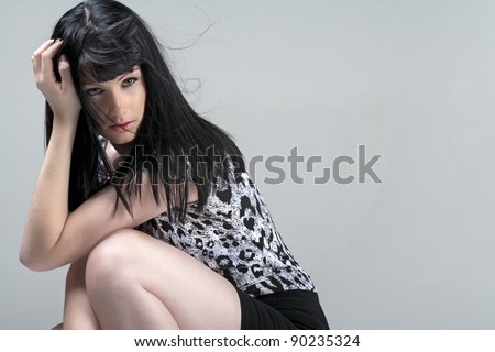 Young woman crouching in black skirt