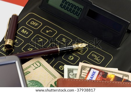Calculator, credit card, cash, gold?n pen and cell phone on a business workplace