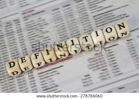 Definition word built with letter cubes on newspaper background